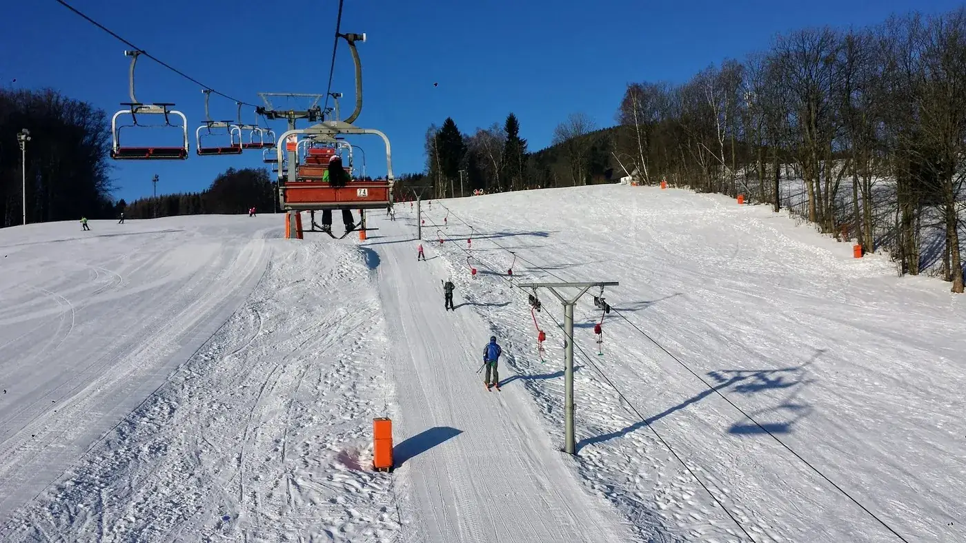 Vlek a sjezdovka na SKI Bubákově pod modrou oblohou