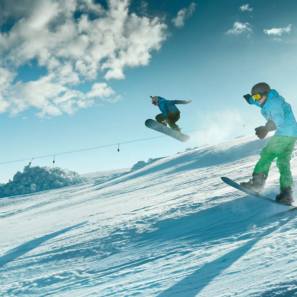 Snowboardisté na svahu za slunečného dne